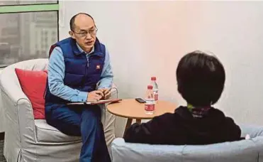  ?? PIC AFP ?? Marriage counsellor Zhu Shenyong (left) advising a client in Shanghai recently.