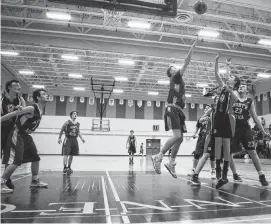  ??  ?? The NNEC Gryphons and NRHS Nighthawks battle under the rim.