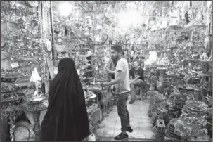  ?? The Associated Press ?? STEPPED-UP SANCTIONS: A woman shops at the old main bazaar in Tehran, Iran, Monday. Iranians shrugged off the possibilit­y that a bellicose exchange of words between President Donald Trump and his Iranian counterpar­t could escalate into military conflict, but expressed growing concern America’s stepped-up sanctions could damage their fragile economy.