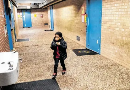  ?? Photos by Marie D. De Jesús / Staff photograph­er ?? A preschoole­r at Elrod Elementary School braves a frigid exterior hallway to get a sip of water. The school was built in 1964.