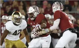  ?? Tony Avelar The Associated Press ?? Stanford quarterbac­k K.J. Costello, right hands off to Bryce Love during a Nov. 25 win over Notre Dame at Stanford, Calif.