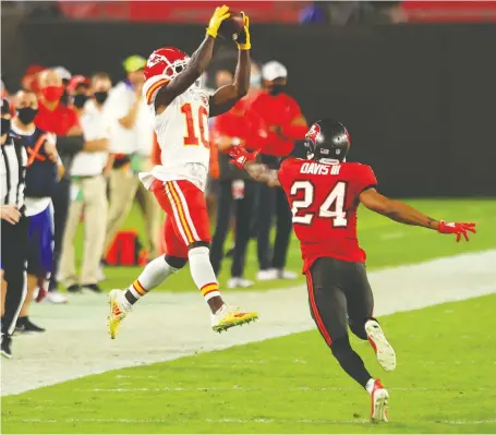  ?? MIKE EHRMANN/ GETTY IMAGES ?? Tyreek Hill of the Kansas City Chiefs makes a leaping catch against Carlton Davis of the Tampa Bay Buccaneers during their game at Raymond James Stadium on Sunday in Tampa. Hill had three touchdowns in the Chiefs' 27-24 win over the Buccaneers.