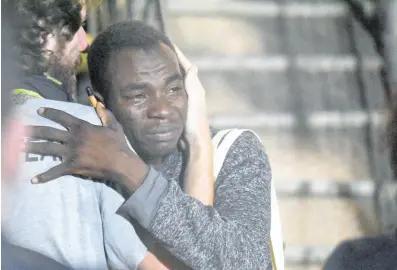  ?? AP ?? A man cries as he hugs a crew member after disembarki­ng from the ‘Open Arms’ rescue ship on the Sicilian island of Lampedusa, southern Italy, on Tuesday.