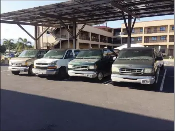  ?? Photo courtesy of Gene Zarro ?? Passenger vans sit in the parking lot of Kihei Charter School. Thieves stole the catalytic converters from four of the vans about two weeks ago, leaving the school with a hefty bill and a limited fleet of vehicles.