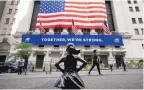  ?? MARK LENNIHAN/ASSOCIATED PRESS ?? The Fearless Girl statue stands in front of the New York Stock Exchange in New York. Wall Street closed out the year with more record highs Thursday.