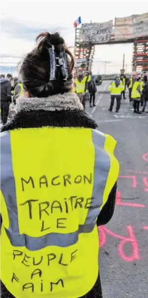  ?? BILD: SN/AFP ?? „Macron, Verräter. Das Volk hungert“, steht auf einer der Warnwesten, die zum Symbol für die landesweit­en Proteste geworden sind.