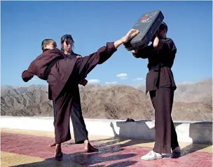  ??  ?? Buddhist nuns help a participan­t learn Kung Fu, a form of martial art, during a five-day workshop in Hemis region in Ladakh, India. Reuters / Nita Bhalla