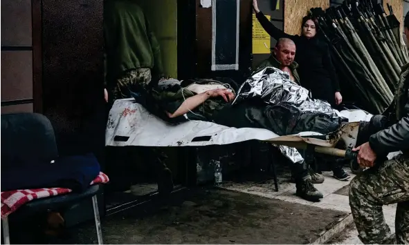  ?? FOTO: TT-AP ?? ■ Ukrainska soldater bär en sårad kamrat in i sjukhuset i Bakhmut i Donetskreg­ionen.