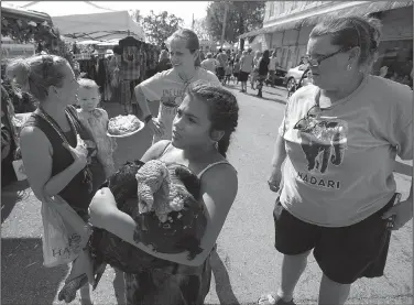  ?? NWA Democrat-Gazette/ANDY SHUPE ?? Sierra Martinez, 12, (center), of Yellville holds a wild turkey she caught Saturday after it was released from a stage as Angie Heringer (top), founder and executive director of ARC Angels 4 Animals, and animal rights activist Ruth Scroggin, both of...