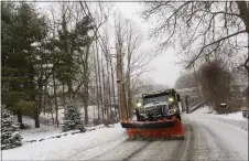  ?? KRISTOPHER RADDER - VIA THE ASSOCIATED PRESS ?? A snowplow on Maple Street in Brattlebor­o, Vt., while the snow falls on Saturday. New England battled a mix of wind, rain, sleet and heavy snow.