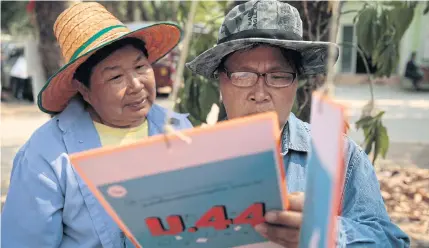  ?? PATIPAT JANTHONG ?? Participan­ts of “We Walk” campaign, a 450km march from Thammasat University’s Rangsit campus in Pathum Thani to Khon Kaen, read a document handed out on the last day of the campaign aimed to highlight issues the regime has failed to address.