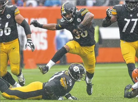  ?? Matt Freed/Post-Gazette ?? James Conner hurdles center Maurkice Pouncey into a hole Sunday in Cleveland.