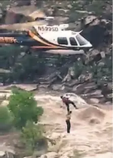  ?? Pima County Sheriff’s Department ?? An image from video shows a stranded hiker being lifted to safety Sunday from flash flooding on the outskirts of Tucson.