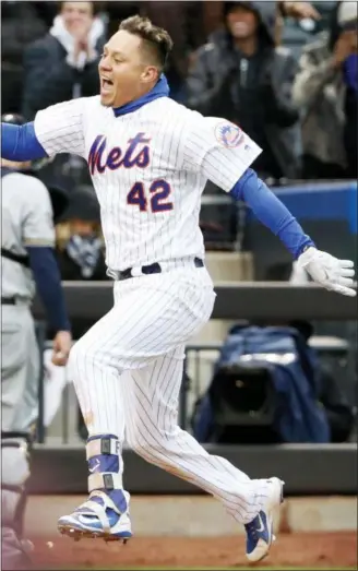  ?? KATHY WILLENS — ASSOCIATED PRESS ?? Mets’ Wilmer Flores celebrates after hitting his game-winning homer at Citi Field in New York on Sunday. Brewers catcher Jeff Bandy, left, leaves the field.