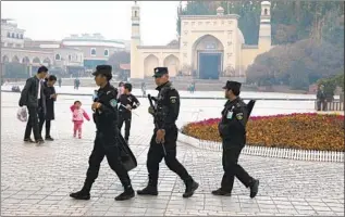  ?? SECURITY PERSONNEL Ng Han Guan Associated Press ?? patrol near a mosque in China’s Xinjiang region in 2017. Beijing has locked up more than a million Uighurs and other Muslim minorities, activists and survivors say.