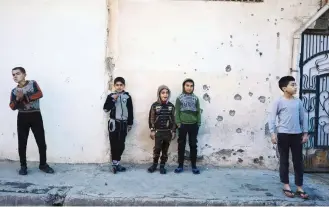  ?? — AFP ?? Boys stand watching as demining experts from the Iraqi army search for booby-trapped buildings in eastern Mosul during an ongoing military operation against IS group.