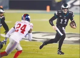  ?? Associated Press photo ?? Philadelph­ia Eagles’ Carson Wentz scrambles during the first half of an NFL football game against the New York Giants, Thursday in Philadelph­ia.