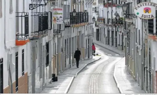  ?? ANTONIO L. JUÁREZ / PHOTOGRAPH­ERSSPORTS ?? Un hombre caminando ayer por una calle casi desierta en el municipio granadino de Montefrío.