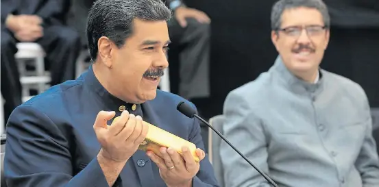  ?? AFP ?? Risas. Maduro muestra un lingote de oro durante un acto político. En 2012, Hugo Chávez había repatriado 260 toneladas de oro de reservas.