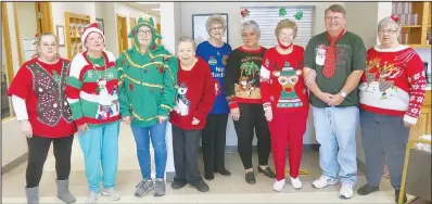  ?? (NWA Democrat-Gazette/Susan Holland) ?? Entrants in the ugly sweater contest at Billy V. Hall Senior Activity Center line up for a photo Dec. 16 just before Christmas dinner. Pictured are Snooky Garrett, Mary Griffin, Cheryl Waeltz, Linda Hartzell, Jeanie Easley, LaVonda Augustine, Juanita Whiteside, Jack Kinney and Sue Rice.