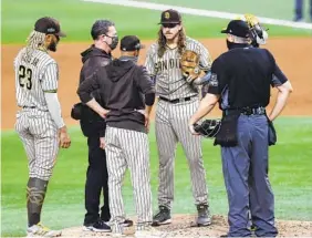  ?? K.C. ALFRED U-T ?? Padres right-hander Mike Clevinger (facing) is pulled by manager Jayce Tingler (third from left) in the second inning Tuesday night against the Dodgers.