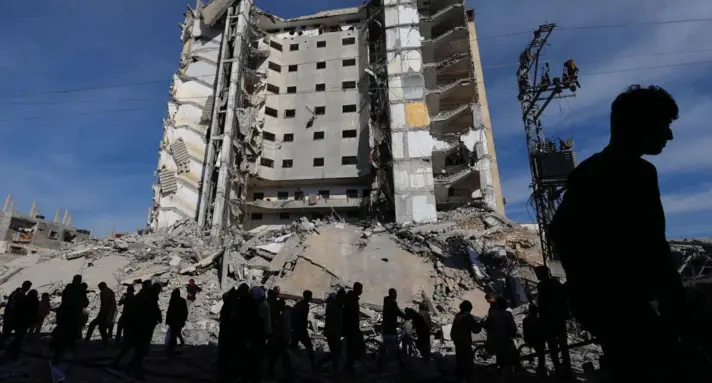  ?? ?? ► Palestinos se reúnen cerca de un edificio dañado en un ataque aéreo israelí, en Rafah, en el sur de la Franja de Gaza, el 9 de marzo de 2024.