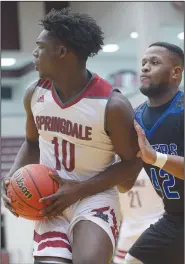  ?? NWA Democrat-Gazette/ANDY SHUPE ?? Springdale High’s Chops Sanders (left) makes a move in the post to avoid Rogers High’s Jaelon Carter on Saturday during the finals of the Siloam Springs Holiday Tournament in Panther Arena in Siloam Springs.