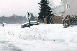  ?? RANDY CONNERS, THE CANADIAN PRESS ?? Snow piles up on a street in Gander, N.L., on Thursday, where more than 35 centimetre­s fell at the airport.
