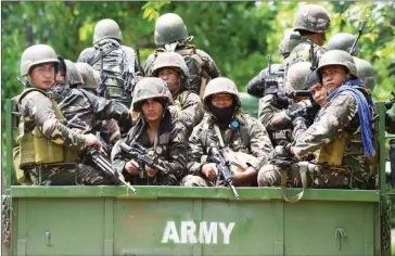  ?? TED ALJIBE/AFP ?? Philippine soldiers arrive to reinforce comrades yesterday at a military camp in Marawi, on the southern island of Mindanao, days after Muslim extremists attacked the city.