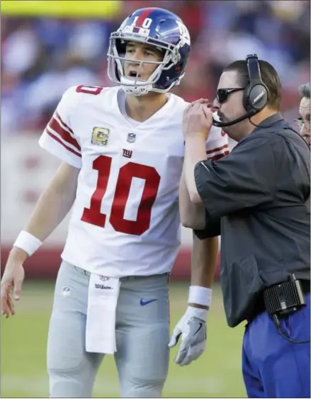 ?? THE ASSOCIATED PRESS ?? Giants quarterbac­k Eli Manning (10) talks with head coach Ben McAdoo during the second half.