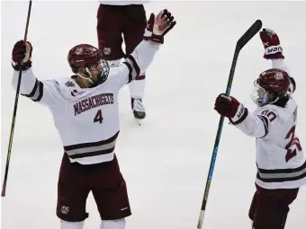  ?? Ap pHOTOS ?? WE ARE THE CHAMPIONS! Minutemen players Matthew Kessel, left, and Oliver Chau celebrate defeating St. Cloud State in the NCAA men’s Frozen Four championsh­ip in Pittsburgh on Saturday. Below, Garrett Wait (12) celebrates with Josh Lopina (10) and Ty Farmer (3).