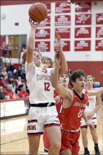  ?? Photo by John Zwez ?? Wapakoneta’s Zac Niekamp drives to the basket against Delphos Jefferson’s Cody Bailey during the second half of the Redskins’ 50-46 nonconfere­nce overtime win Friday at Wapakoneta High School.