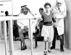  ??  ?? Amani, a 10-year-old Syrian amputee from the eastern province of Deir Ezzor, is helped as she tries to walk with her new artificial limb at the Syrian Arab Red Crescent facility, in the capital Damascus. — AFP photo