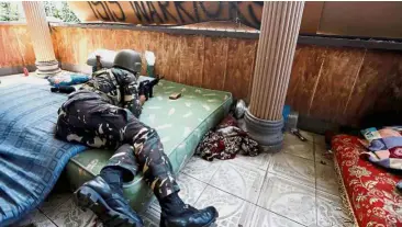  ?? — Reuters ?? Staying vigilant: A Filipino soldier lies on a mattress in combat position as government troops continue their recent assault against insurgents in Marawi city.