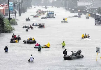  ?? FOTO: DPA ?? Wasser und kein Ende: Boote werden am Dienstag in Houston auf einer überflutet­en Straße zur Evakuierun­g von Flutopfern eingesetzt.