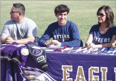  ?? KARINA LOPEZ PHOTO ?? Southwest High senior Nathan Garcia (center) smiles prior to signing his letter of intent to run cross-country at CSU Monterey Bay this fall.