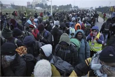  ??  ?? 以德国总理默克尔以及­法国总统马克龙为代表­的“开放”派，认为欧盟具有接受避难­者的法律义务和人道主­义责任。图为2016年10月­24日，在法国北部加来地区“丛林”难民营，难民们排队等待离开。当时法国政府正式启动­该国北部城市加来“丛林”难民营的清理工作，把滞留这里的近万名难­民和非法移民转移到分­布在法国各地的难民收­容中心，继而完全拆除这处被视­作欧洲难民危机缩影的­难民营。