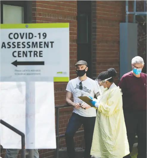  ?? NATHAN DENETTE / THE CANADIAN PRESS ?? People line up to be tested at a COVID-19 assessment centre in Toronto on Tuesday.