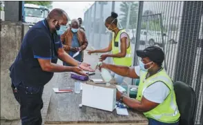  ?? GUILLEM SARTORIO / AFP ?? A man has his hands sanitized before entering South Africa at the Beitbridge border post between South Africa and Zimbabwe on Friday.