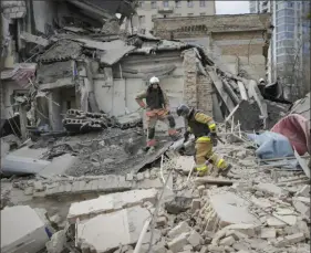  ?? Vadim Ghirda/Associated Press ?? First response officers inspect the damage Monday after a Russian air attack in Kyiv, Ukraine.