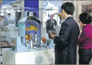  ?? REUTERS ?? Visitors look at a Westinghou­se Electric Corp’s nuclear power plant model at a trade fair for the global nuclear energy sector in Paris.