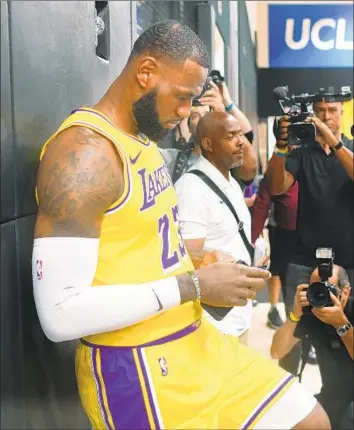  ?? Wally Skalij Los Angeles Times ?? LeBRON JAMES, checking his phone during media day in El Segundo, was surprising­ly stoic Monday. But perhaps that’s just a sign that he’s ready to take care of business, and sending a message to new teammates.