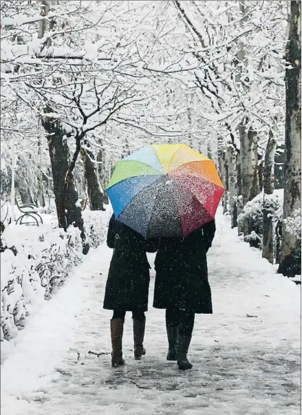 ?? VAHID SALEMI / AP ?? Una pareja paseaba ayer por el parque Laleh de Teherán, cubierto por una intensa nevada