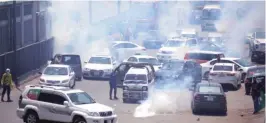  ?? ?? Police fire tear gas to disperse supporters of Imran Khan’s party — the Tehreek-e-insaf — in Lahore, from marching towards Islamabad, on Tuesday