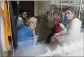  ?? CZAREK SOKOLOWSKI — THE ASSOCIATED PRESS ?? Boshra al-Moallem, bottom left, looks out of the window as she sits in a room with her two sisters and brother-in-law at a refugee center in Bialystok, Poland, on Wednesday.