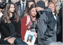  ?? JACQUELYN MARTIN THE ASSOCIATED PRESS ?? Lori Alhadeff, centre, is comforted at a news conference by husband Ilan Alhadeff as she holds a photo of their daughter, Alyssa Alhadeff, 14, who was killed in the shootings at Marjory Stoneman Douglas High School.
