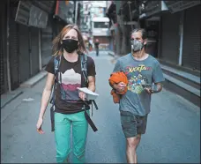  ?? TOM VAN CAKENBERGH­E/THE NEW YORK TIMES ?? Ana Pautler, left, and Mike Dobie return to their hotel through deserted streets Thursday in Kathmandu, Nepal.