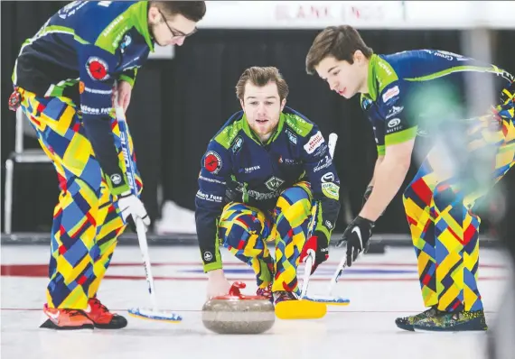  ?? MATT SMITH FILES ?? Skip Rylan Kleiter delivers as teammates Joshua Mattern, left, and Matthieu Taillon prepare to sweep during the provincial junior curling championsh­ips in December.