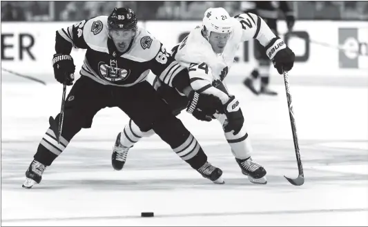  ?? Photo: VCG ?? Brad Marchand (left) of the Boston Bruins and Kasperi Kapanen of the Toronto Maple Leafs battle for control of the puck on Wednesday at TD Garden in Boston, Massachuse­tts.