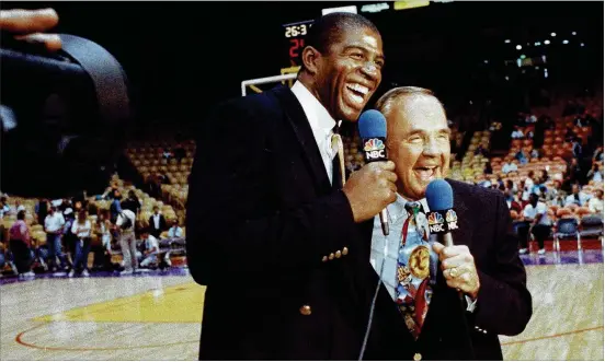  ?? ASSOCIATED PRESS ?? Former NBA star Earvin “Magic” Johnson shares a pregame laugh in February 1992 with Dick Enberg, the legendary broadcaste­r who died Thursday at 82.